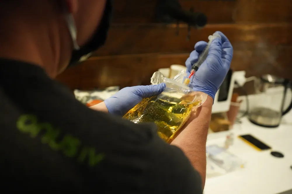 Onus nurse preparing an IV bag with a syringe